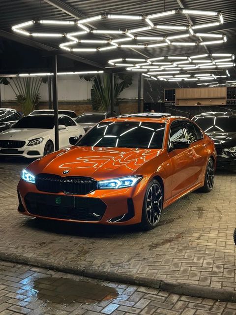 BMW 320i com envelopamento laranja, vista dianteira em três quartos (foto 1 de 20)