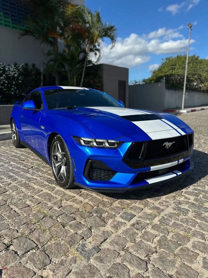 Ford Mustang na cor azul com faixas brancas, vista dianteira em três quartos