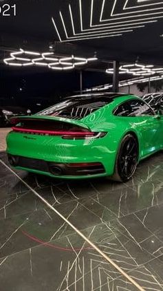 Traseira do 911 Carrera verde sob as luzes do showroom