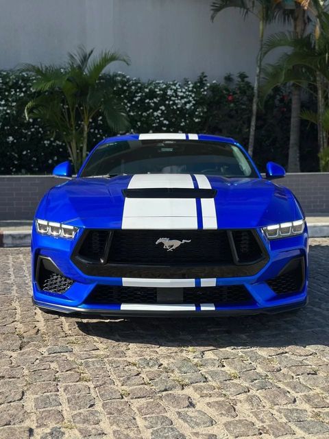 Ford Mustang na cor azul com faixas brancas, vista de frente