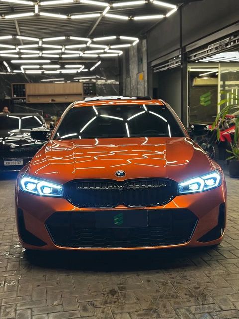 BMW 320i com envelopamento laranja, vista de frente