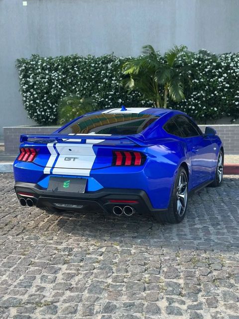 Ford Mustang na cor azul com faixas brancas, vista traseira em três quartos (foto 4 de 20)