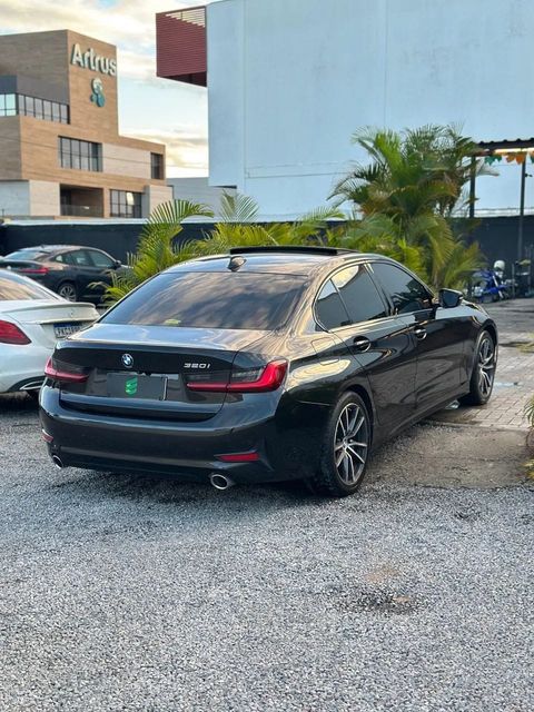 BMW 320i na cor preta, vista traseira em três quartos (foto 4 de 11)