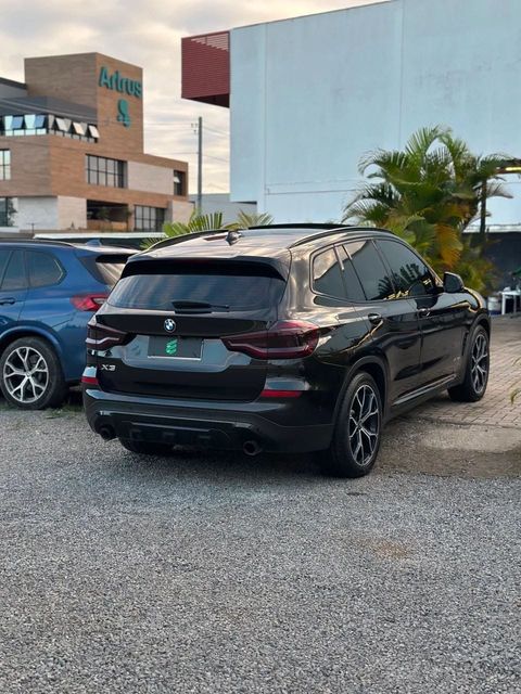 BMW X3 na cor preta, vista traseira em três quartos (foto 4 de 17)